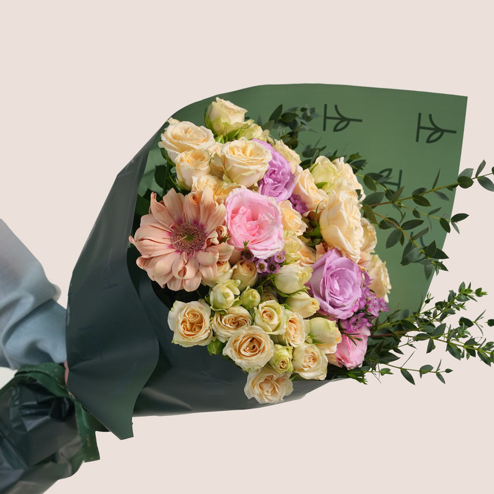 Peach Harmony Mother’s Day flower arrangement with peach roses in TWIGS cone shaped flower carry bag