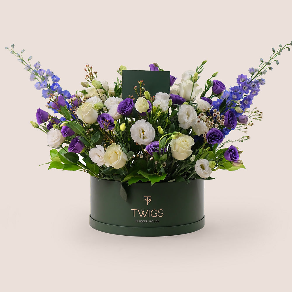 A luxurious mix of purple lisianthus, purple delphiniums, white lisianthus, and Mondial garden roses