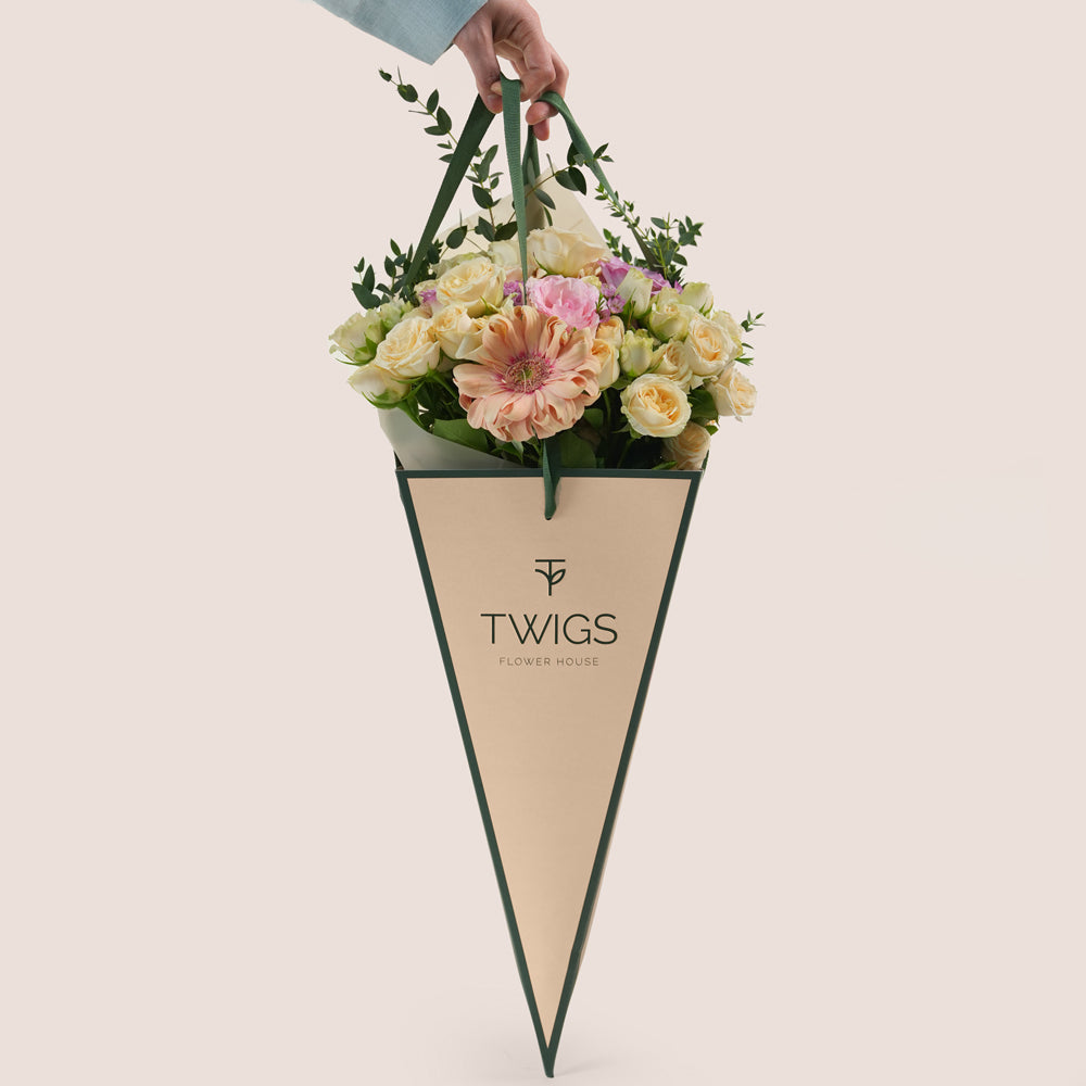 Peach Harmony Mother’s Day flower arrangement with peach roses in TWIGS cone shaped flower carry bag
