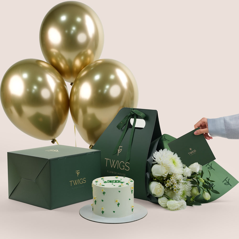 Gold balloons, birthday  cake, and flowers 