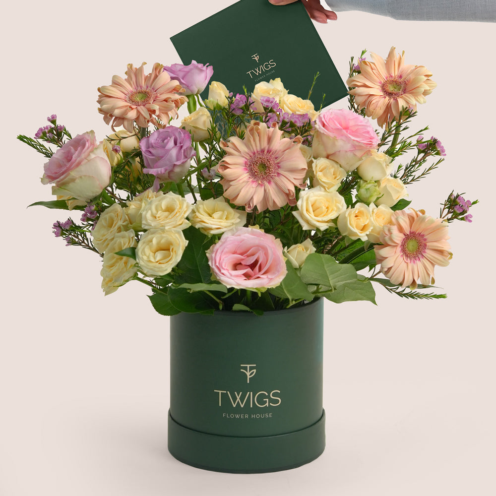 Birthday flower arrangement with peach gerberas and roses in TWIGS deluxe round flower box