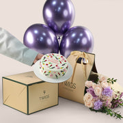 Birthday cake and bouquet of flowers with purple balloons