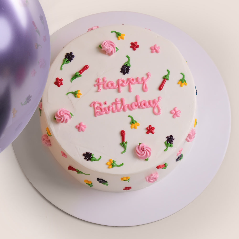 Birthday cake and bouquet of flowers with purple balloons