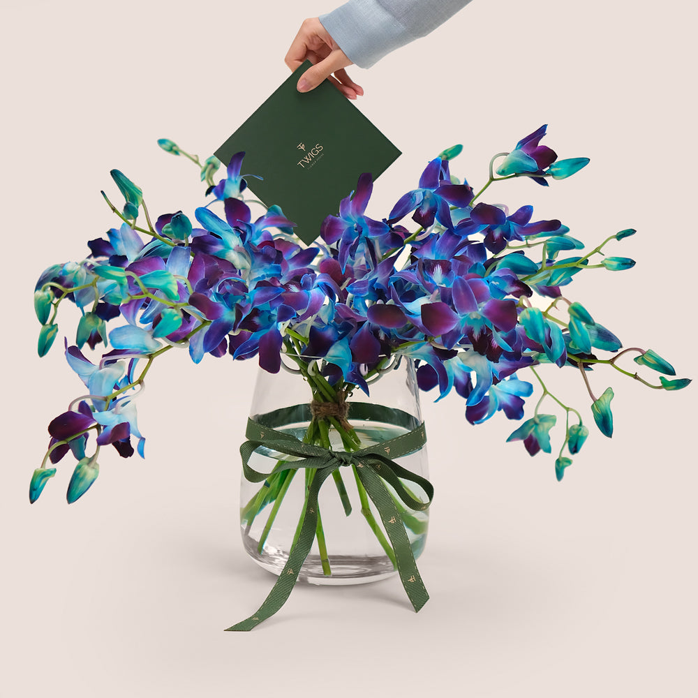 Bouquet of blue and purple orchids in a clear vase 