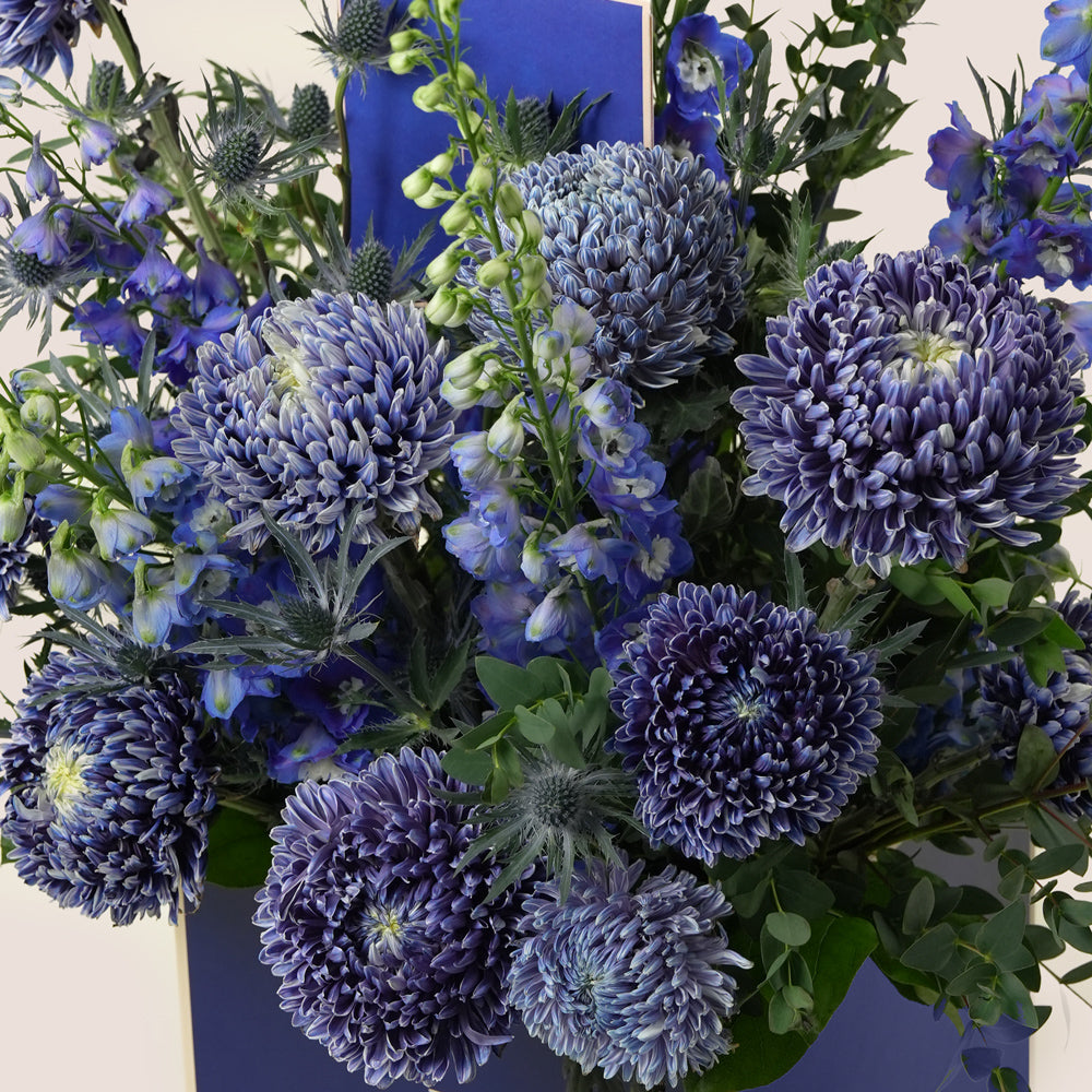 Bouquet of blue flowers with green leaves by TWIGS UAE