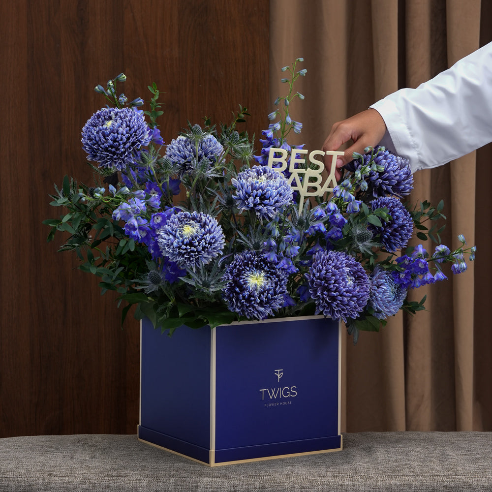 Indigo — blue delphiniums, chrysanthemums and eryngiums in a TWIGS navy square box, Father's Day blue flower arrangement Dubai