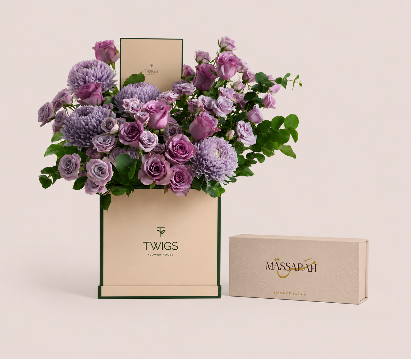 Purple roses and lilac chrysanthemums in a tall green TWIGS box beside a Massarah Her perfume oil set, TWIGS x Light of Sakina collaboration