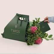 Green Twigs Flower House packaging with a bouquet of flowers on a light background