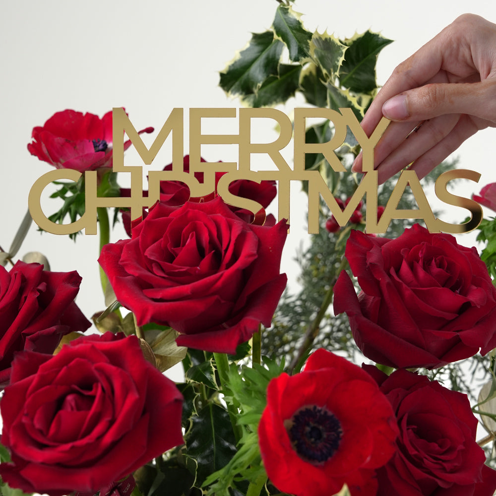 Decorative Christmas sign with red roses and holly leaves