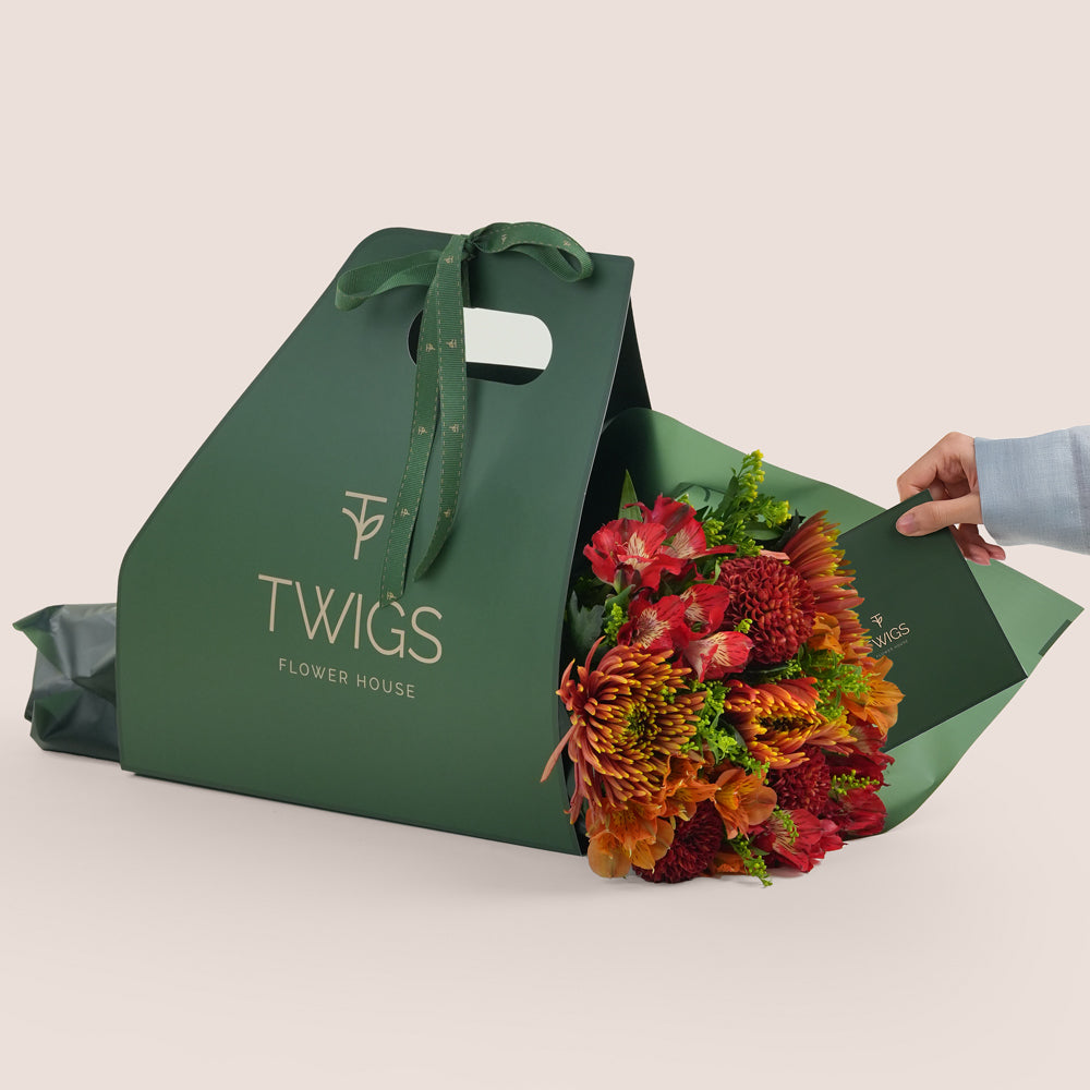 Eid flower bunch with saffina chrysanthemums, burgundy ping pong chrysanthemums and red alstroemerias in TWIGS green carry pack Dubai