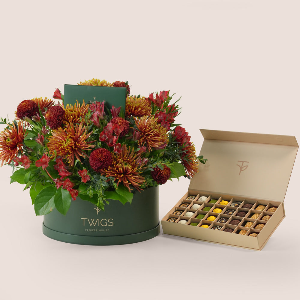 Ruby Eid flower arrangement in grande round box with premium truffles and petite fours gift box Dubai