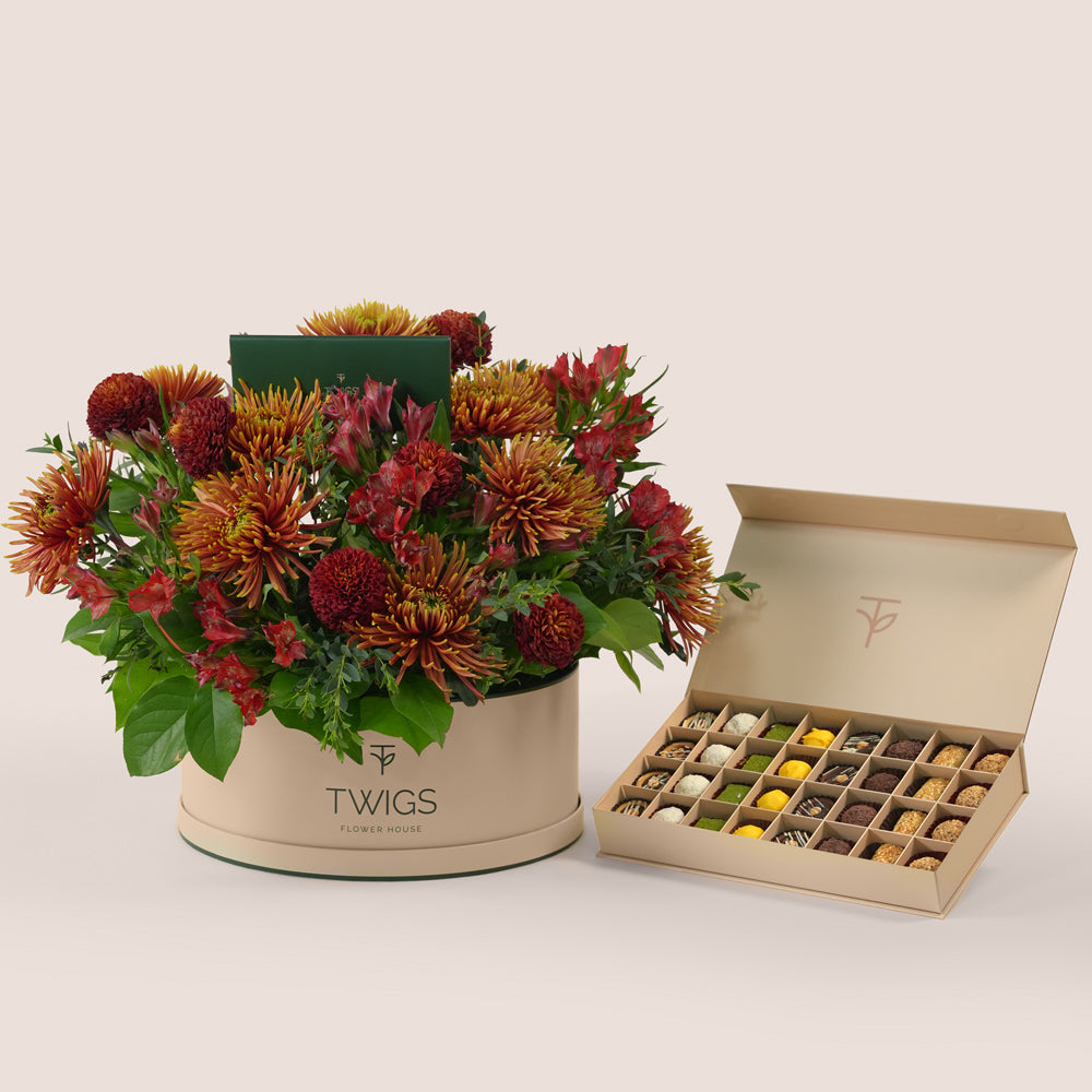 Ruby Eid flower arrangement in grande round box with premium truffles and petite fours gift box Dubai