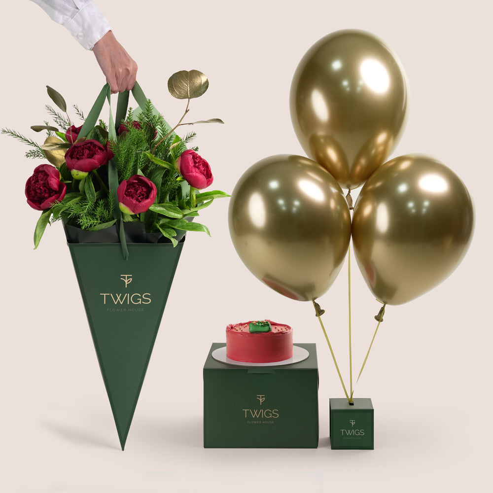 A beautiful festive flower bunch featuring a vibrant red Christmas flower arrangement With red peonies placed beside a decorated cake