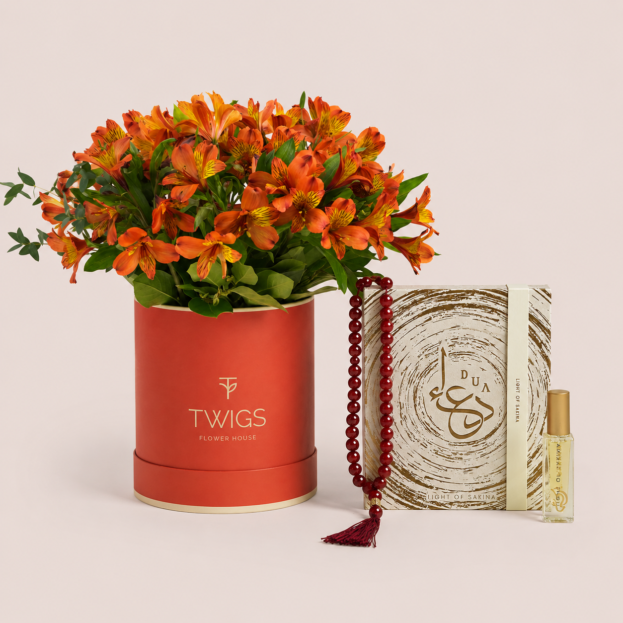 Orange Alstroemeria in a TWIGS box beside a Light of Sakina Aqeeq misbaha and Baraka perfume oil, TWIGS x Light of Sakina collaboration