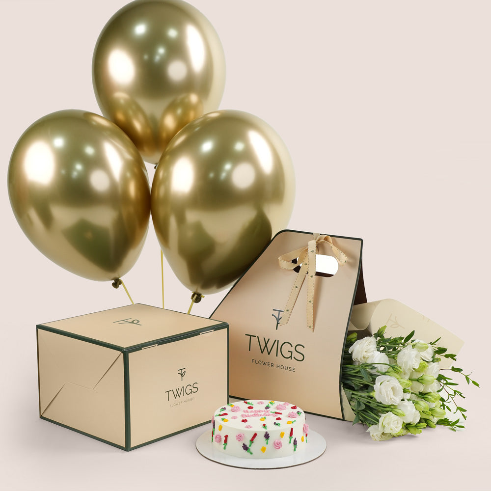 Gold balloons, cake, and bouquet of flowers for birthday