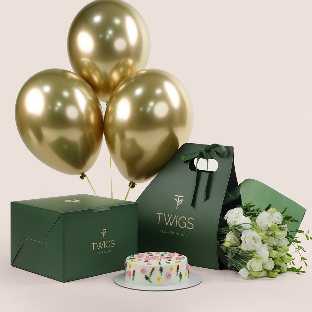 Gold balloons, cake, and bouquet of flowers for birthday