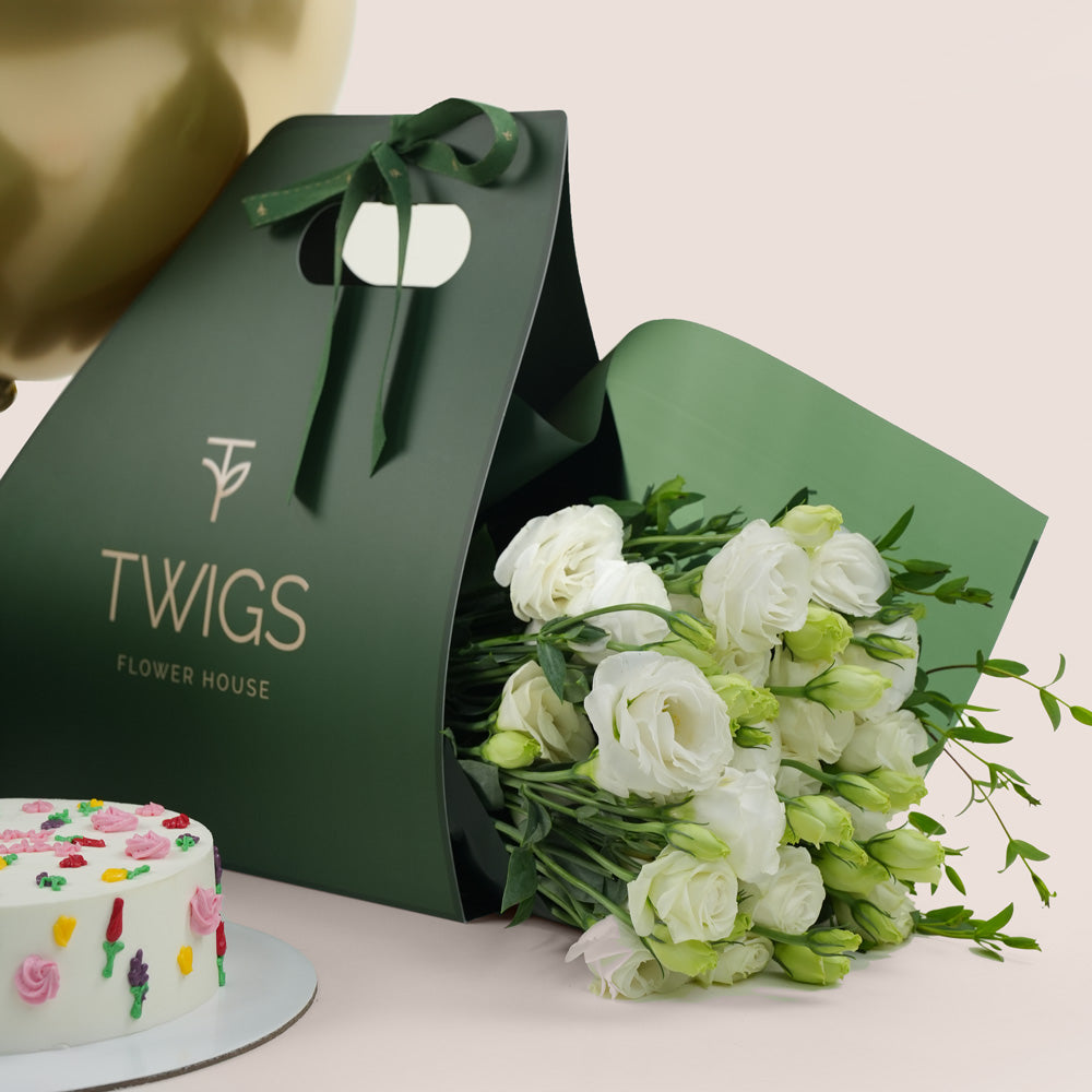 Gold balloons, cake, and bouquet of flowers for birthday