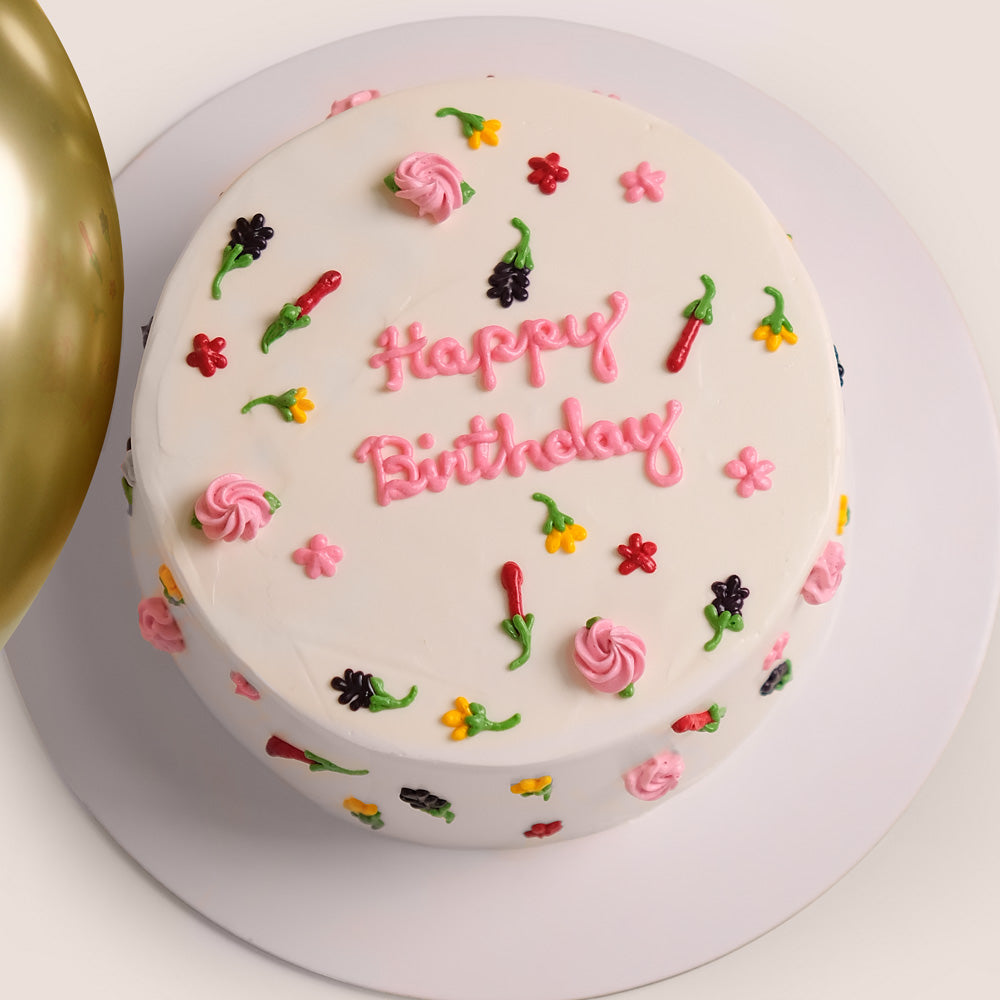 Gold balloons, cake, and bouquet of flowers for birthday