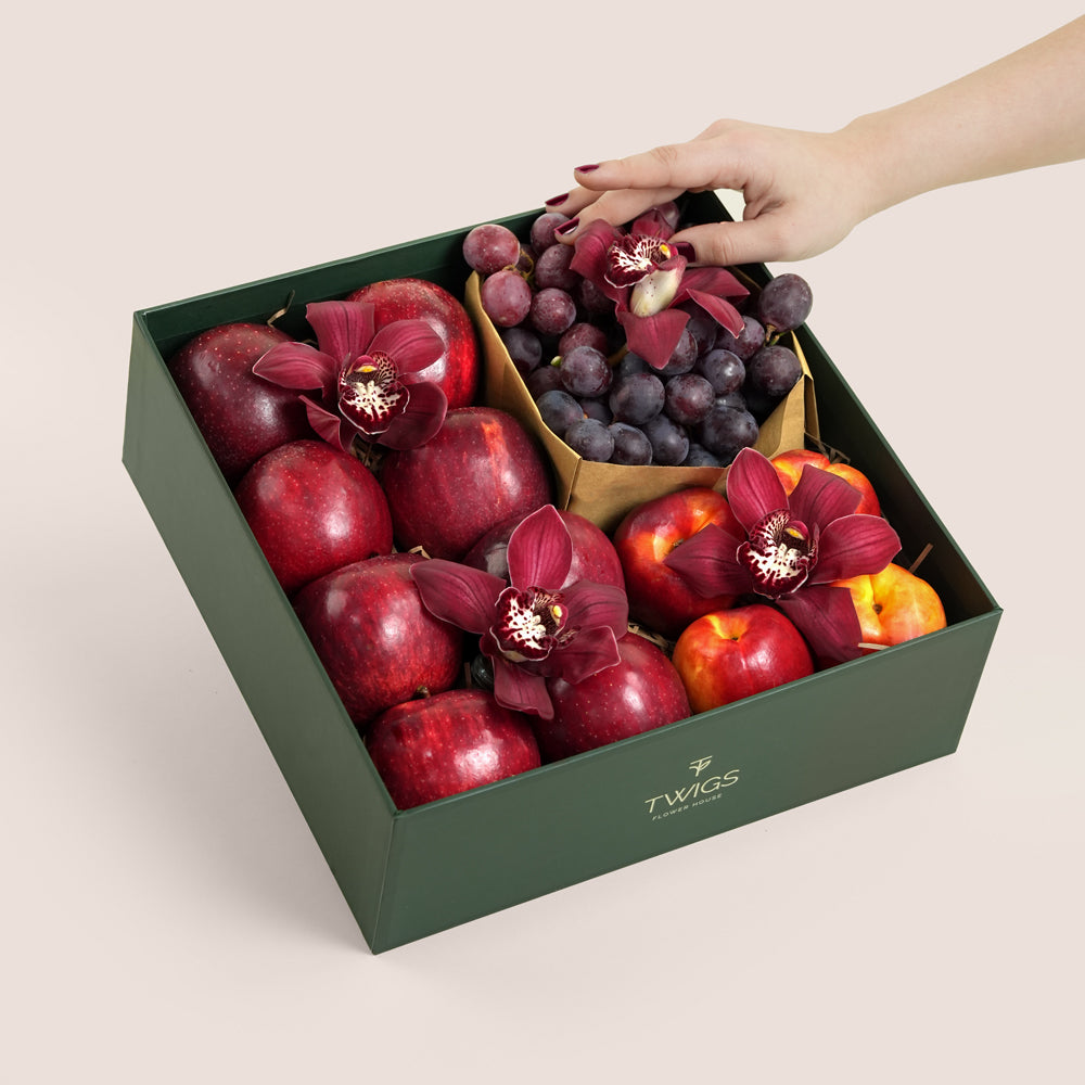 TWIGS Red Box with fresh red apples, nectarines, dark grapes and burgundy cymbidium orchids in a dark green gift box, Dubai UAE