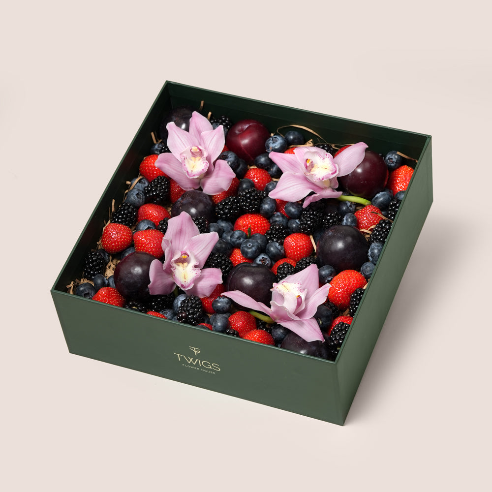 TWIGS Berry Box with fresh strawberries, blackberries, blueberries, dark plums and pink orchids in a dark green gift box, Dubai UAE