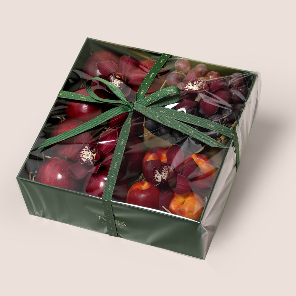 TWIGS Red Box with fresh red apples, nectarines, dark grapes and burgundy cymbidium orchids in a dark green gift box, Dubai UAE