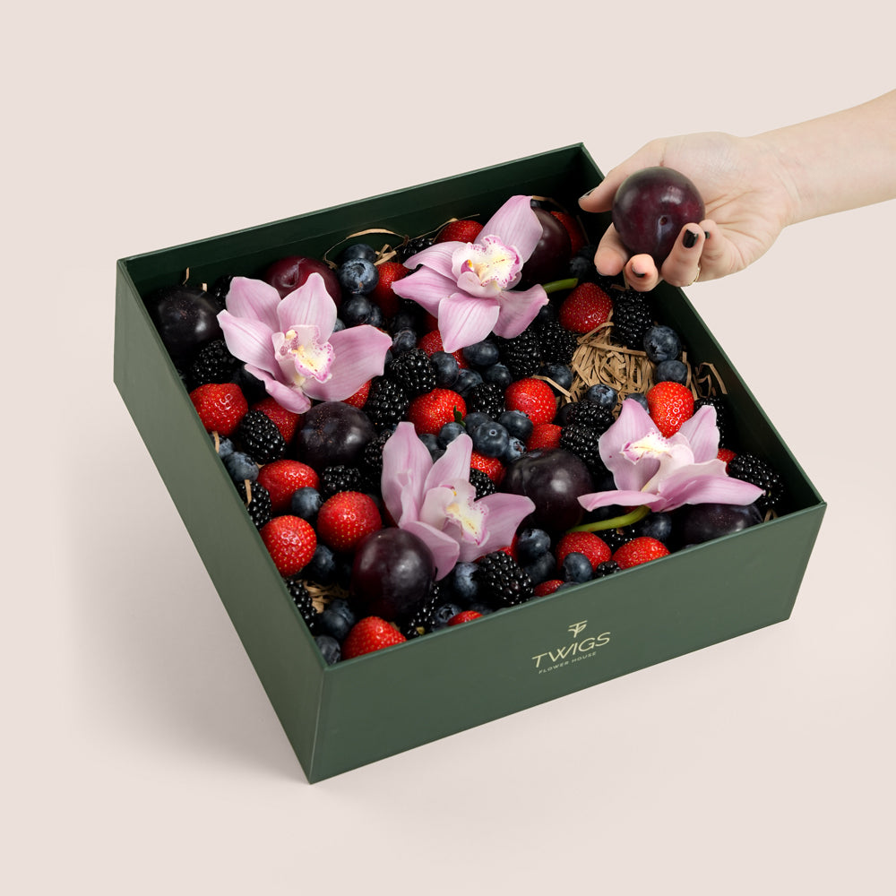TWIGS Berry Box with fresh strawberries, blackberries, blueberries, dark plums and pink orchids in a dark green gift box, Dubai UAE
