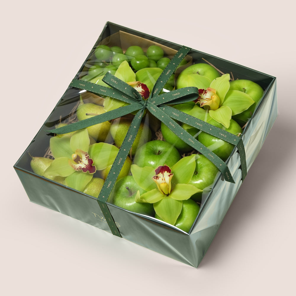 TWIGS Green Box with fresh Granny Smith apples, green pears, green grapes and yellow cymbidium orchids in a dark green gift box, Dubai UAE