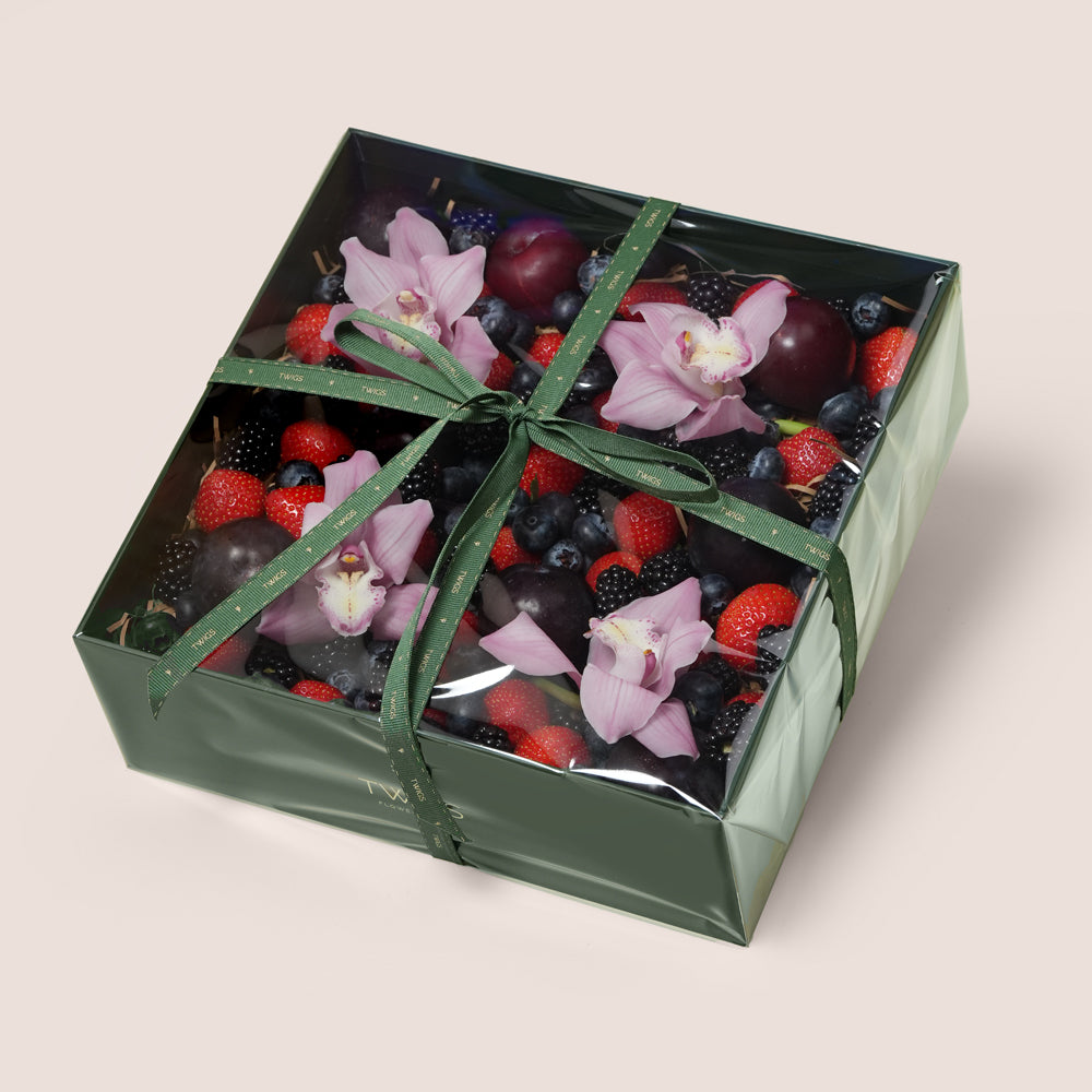TWIGS Berry Box with fresh strawberries, blackberries, blueberries, dark plums and pink orchids in a dark green gift box, Dubai UAE