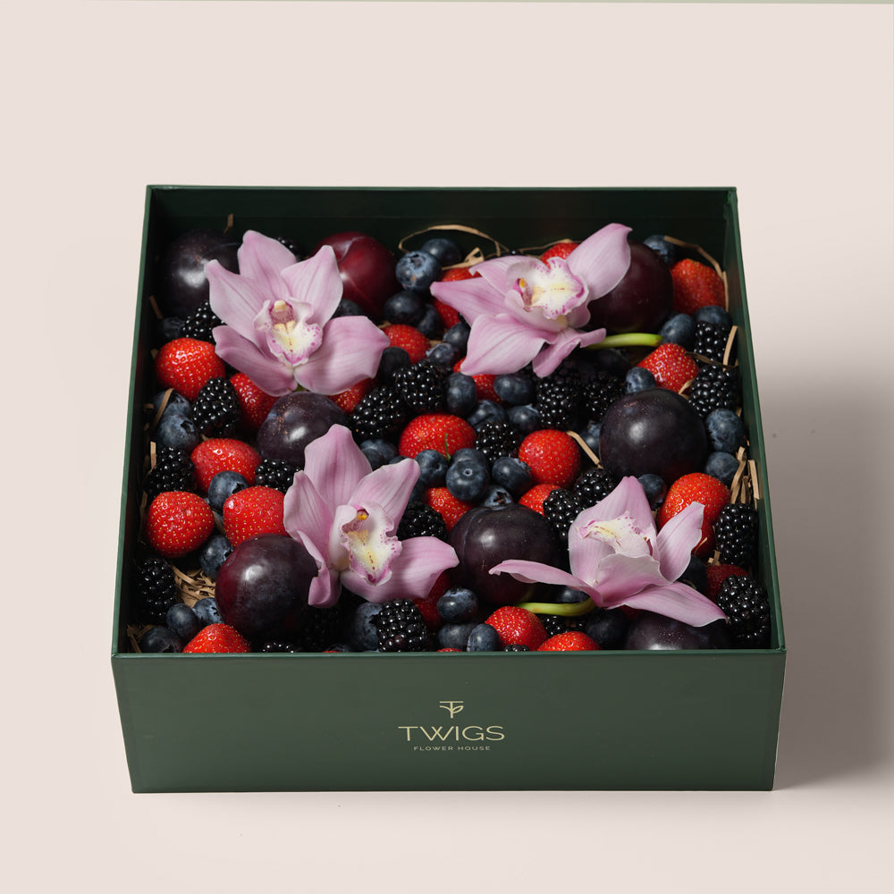 TWIGS Berry Box with fresh strawberries, blackberries, blueberries, dark plums and pink orchids in a dark green gift box, Dubai UAE