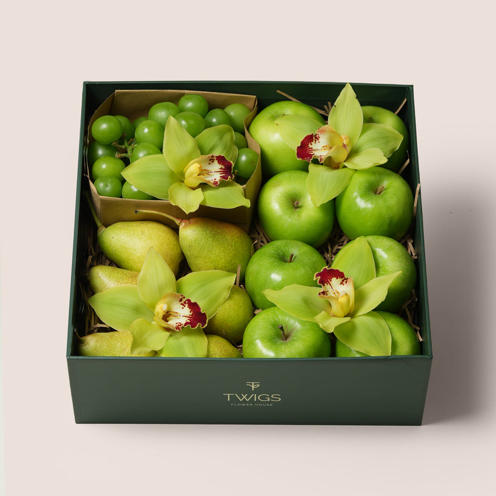 TWIGS Green Box with fresh Granny Smith apples, green pears, green grapes and yellow cymbidium orchids in a dark green gift box, Dubai UAE
