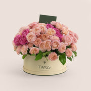 Grande round flower box with premium Juliet spray roses and cerise accents in TWIGS beige or green packaging, available for same day flower delivery in Dubai when you buy flowers online.