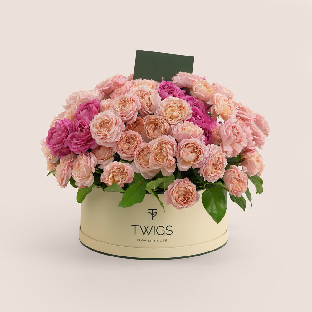 Grande round flower box with premium Juliet spray roses and cerise accents in TWIGS beige or green packaging, available for same day flower delivery in Dubai when you buy flowers online.