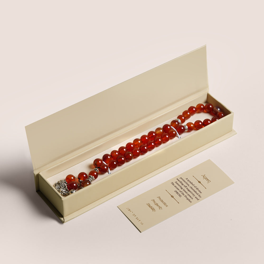 Red Aqeeq misbaha prayer beads with silver accents in an open beige keepsake box, TWIGS x Light of Sakina collaboration