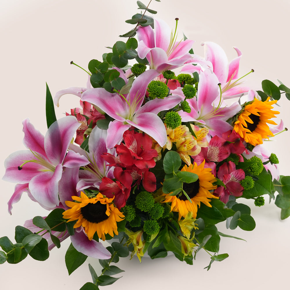 Bouquet of pink lilies, red flowers, and sunflowers 