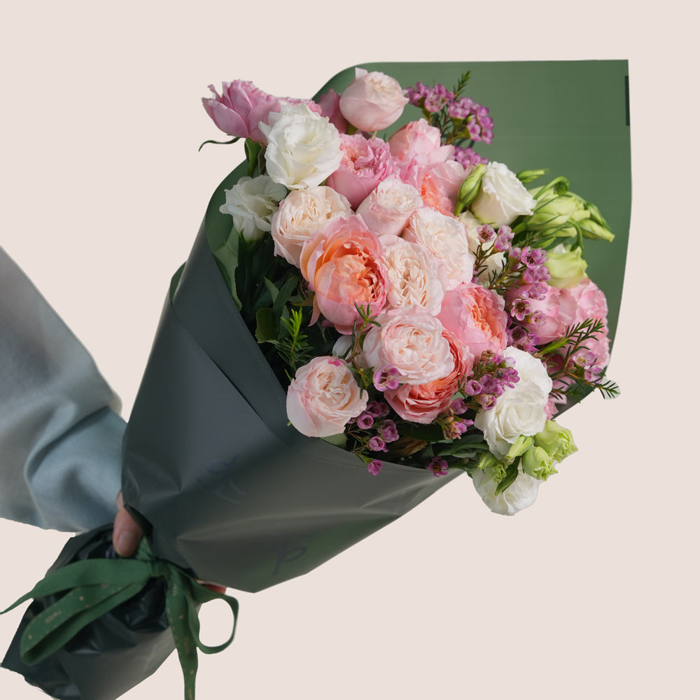 Blushing Bloom Mother’s Day flower arrangement with pink roses in TWIGS cone shaped flower carry bag