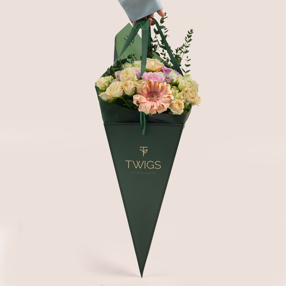 Peach Harmony Mother’s Day flower arrangement with peach roses in TWIGS cone shaped flower carry bag