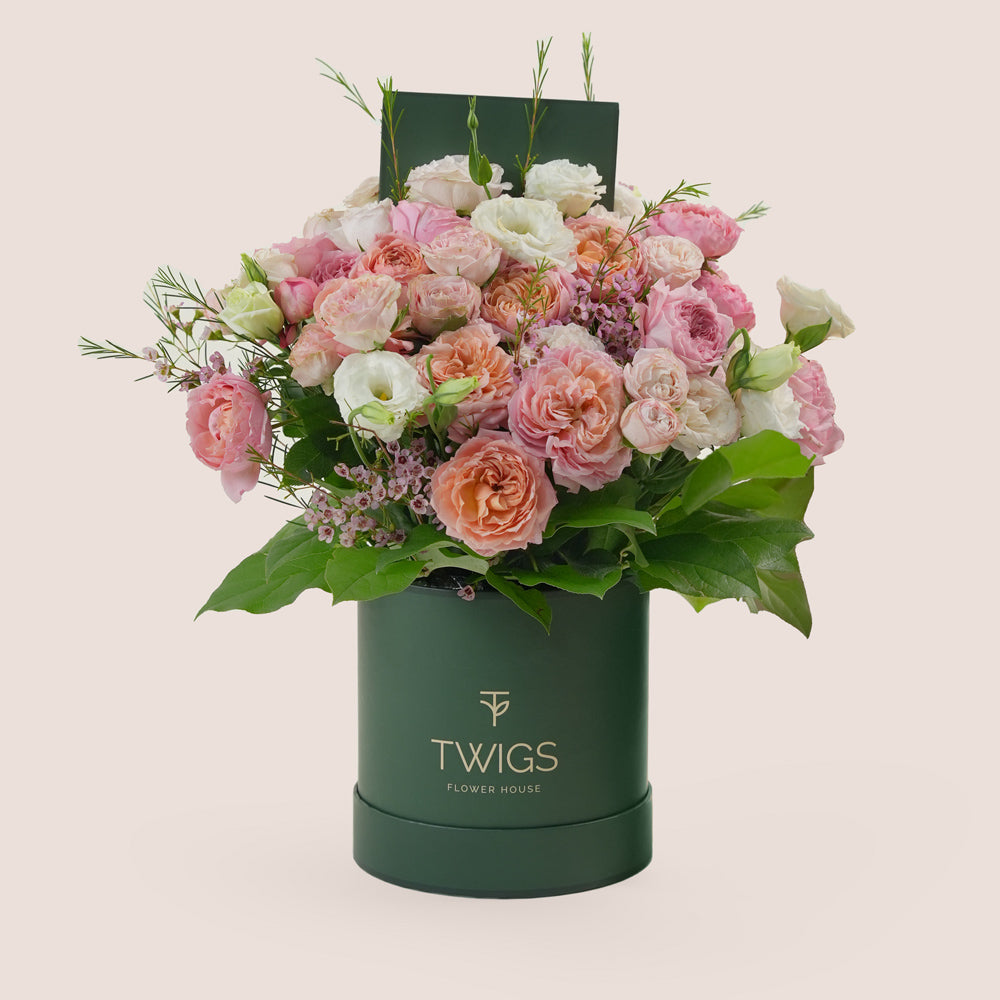 Blushing Bloom Mother’s Day flower arrangement with Juliet spray roses and white lisianthus in TWIGS deluxe round flower box