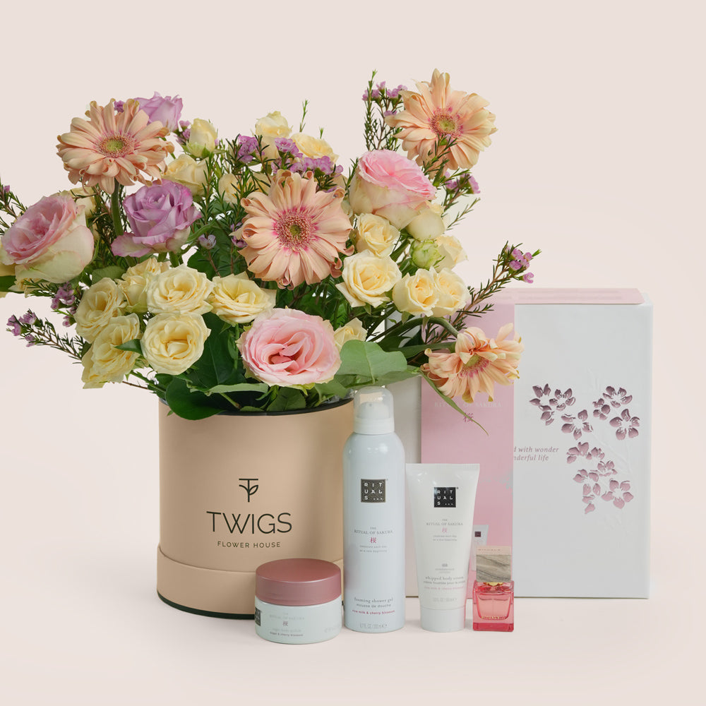 Mother’s Day flower arrangement with peach gerberas and roses in TWIGS green box paired with Rituals Sakura gift set