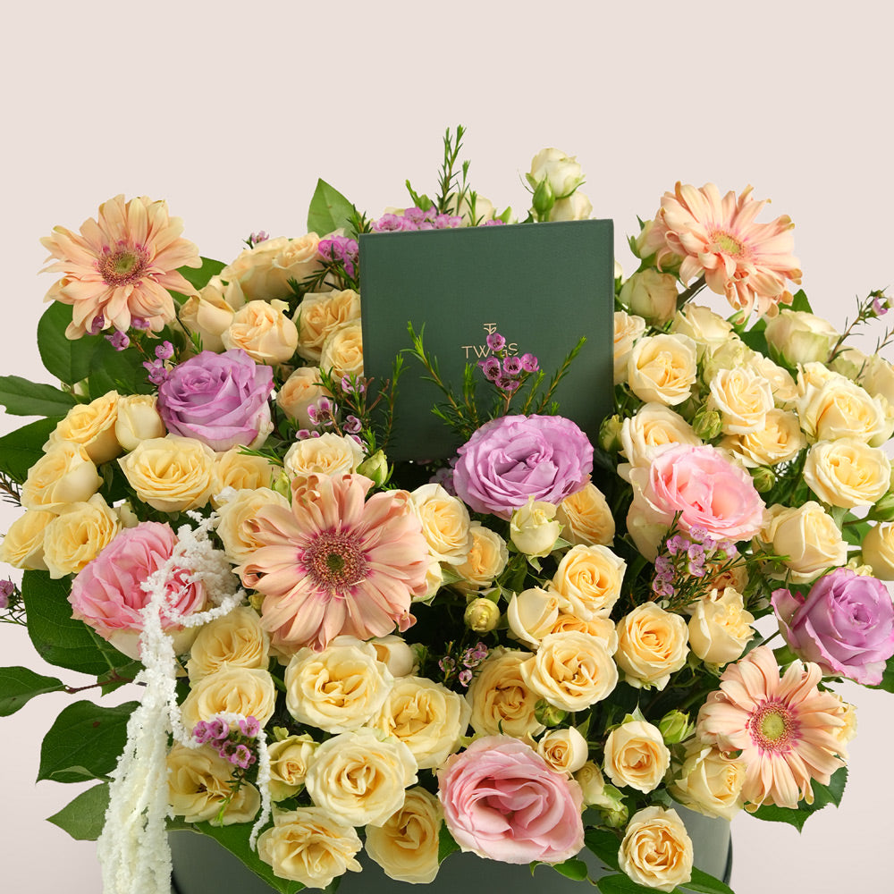Mother’s Day flower arrangement with peach gerberas, spray roses and pink roses in TWIGS beige round box