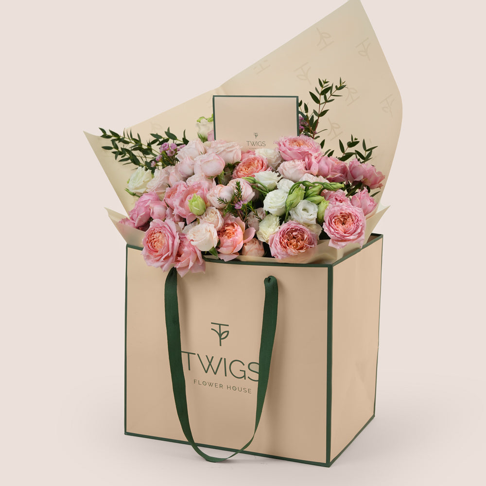Blushing Bloom Mother’s Day flower arrangement with Juliet spray roses and white lisianthus in TWIGS signature flower bag