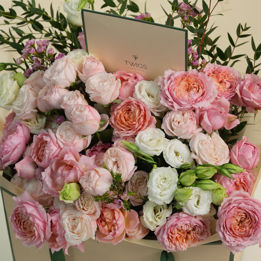 Blushing Bloom Mother’s Day flower arrangement with Juliet spray roses and white lisianthus in TWIGS signature flower bag