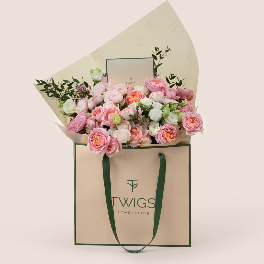 Blushing Bloom Mother’s Day flower arrangement with Juliet spray roses and white lisianthus in TWIGS signature flower bag