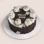 Twigs New Year chocolate cake with "HELLO 2026" text, cream rosettes, and snowflake decorations.