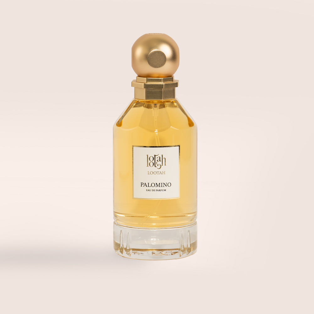 A clear glass bottle of Lootah Palomino Eau de Parfum with a gold-colored cap, labelled with the brand and fragrance name.
