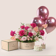 Blush pink floral arrangement with cake and three pink balloons in TWIGS celebration bundle