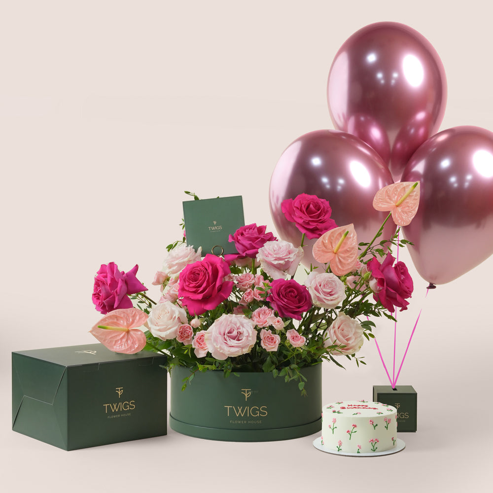 Blush pink floral arrangement with cake and three pink balloons in TWIGS celebration bundle