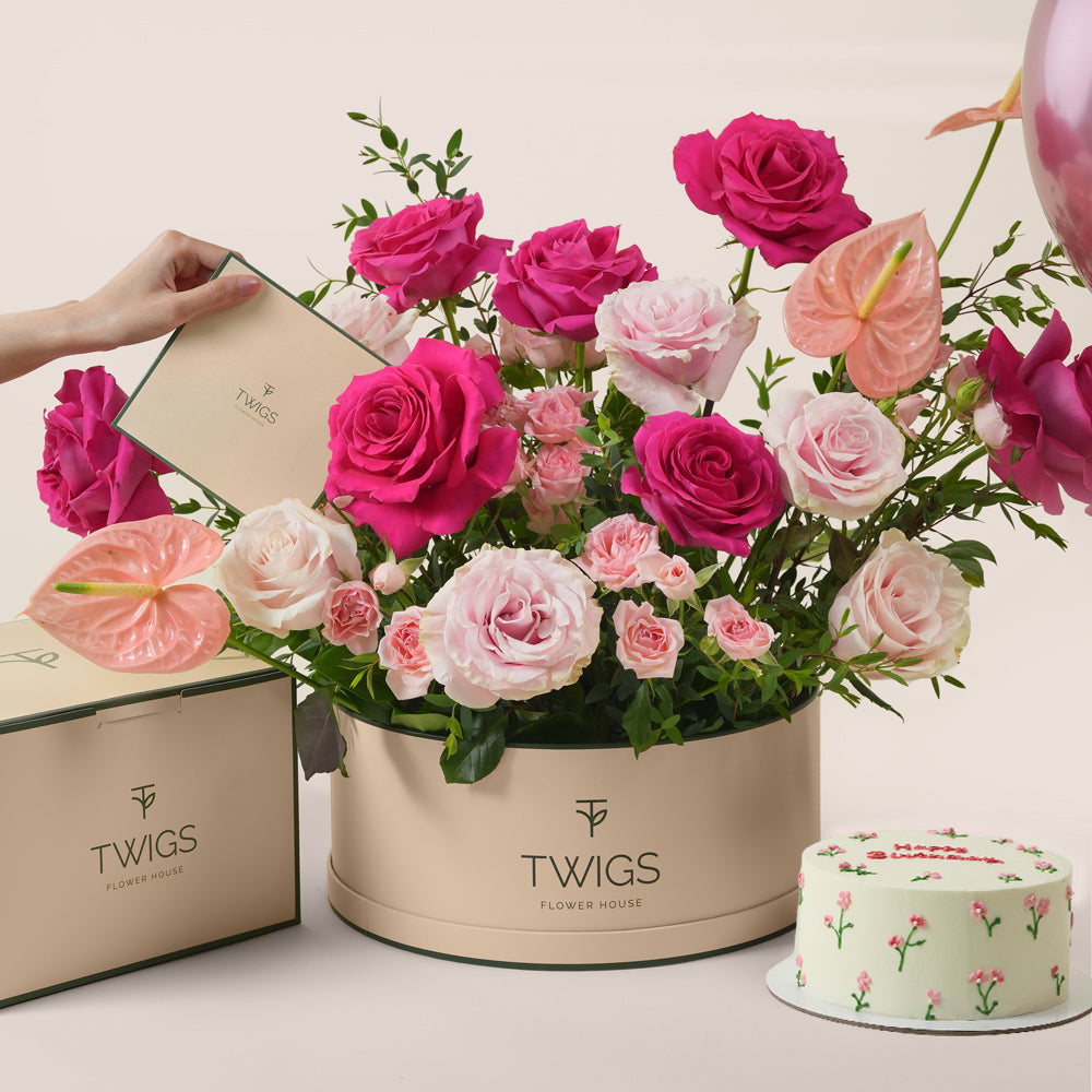 Blush pink floral arrangement with cake and three pink balloons in TWIGS celebration bundle
