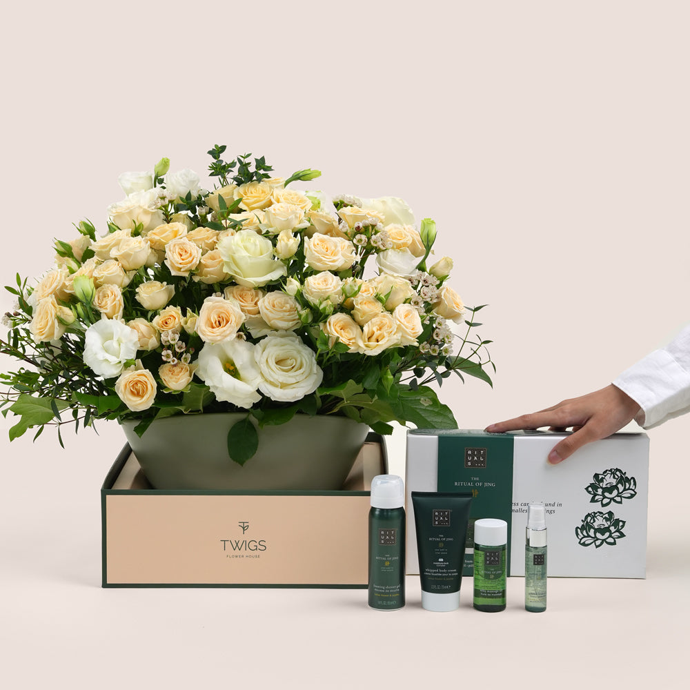 Floral arrangement  with TWIGS , accompanied by skincare products 