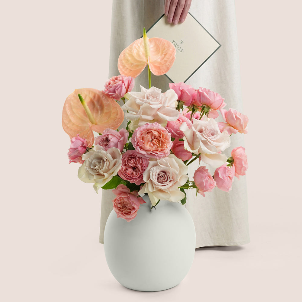 Blush roses and peach anthurium arrangement in TWIGS white matte ceramic vase — Eid Al Adha flower delivery Dubai