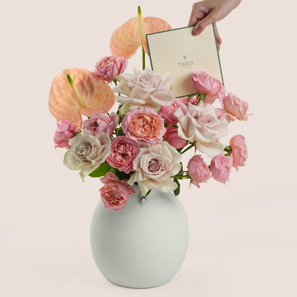 Blush roses and peach anthurium arrangement in TWIGS white matte ceramic vase — Eid Al Adha flower delivery Dubai